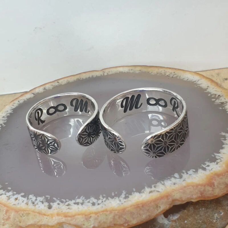 a pair of sterling silver wedding rings, with an etched engraving on the inside