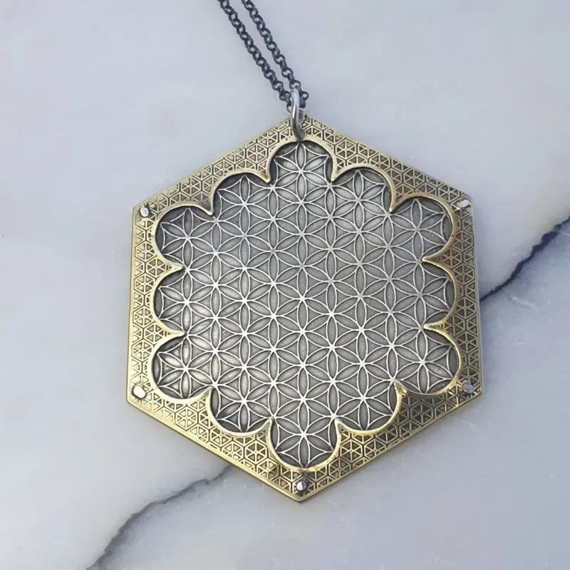 Silver and brass hexagonal pendant with etched Flower of life and sacred geometry designs